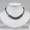Black white and grey satin Kumihimo necklace displayed on white jewelry bust, highlighting spiral braid and beaded focal section